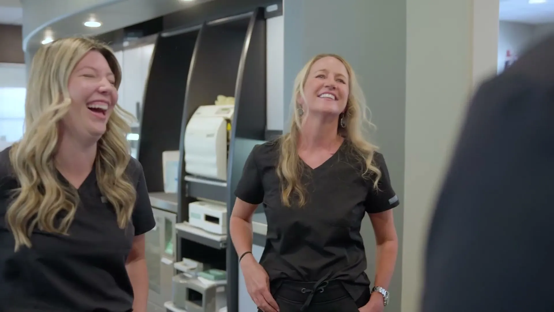 Two Cardinal Point Dental team members laughing together in the office, Jacksonville, FL (cosmetic dentistry and teeth cleanings)