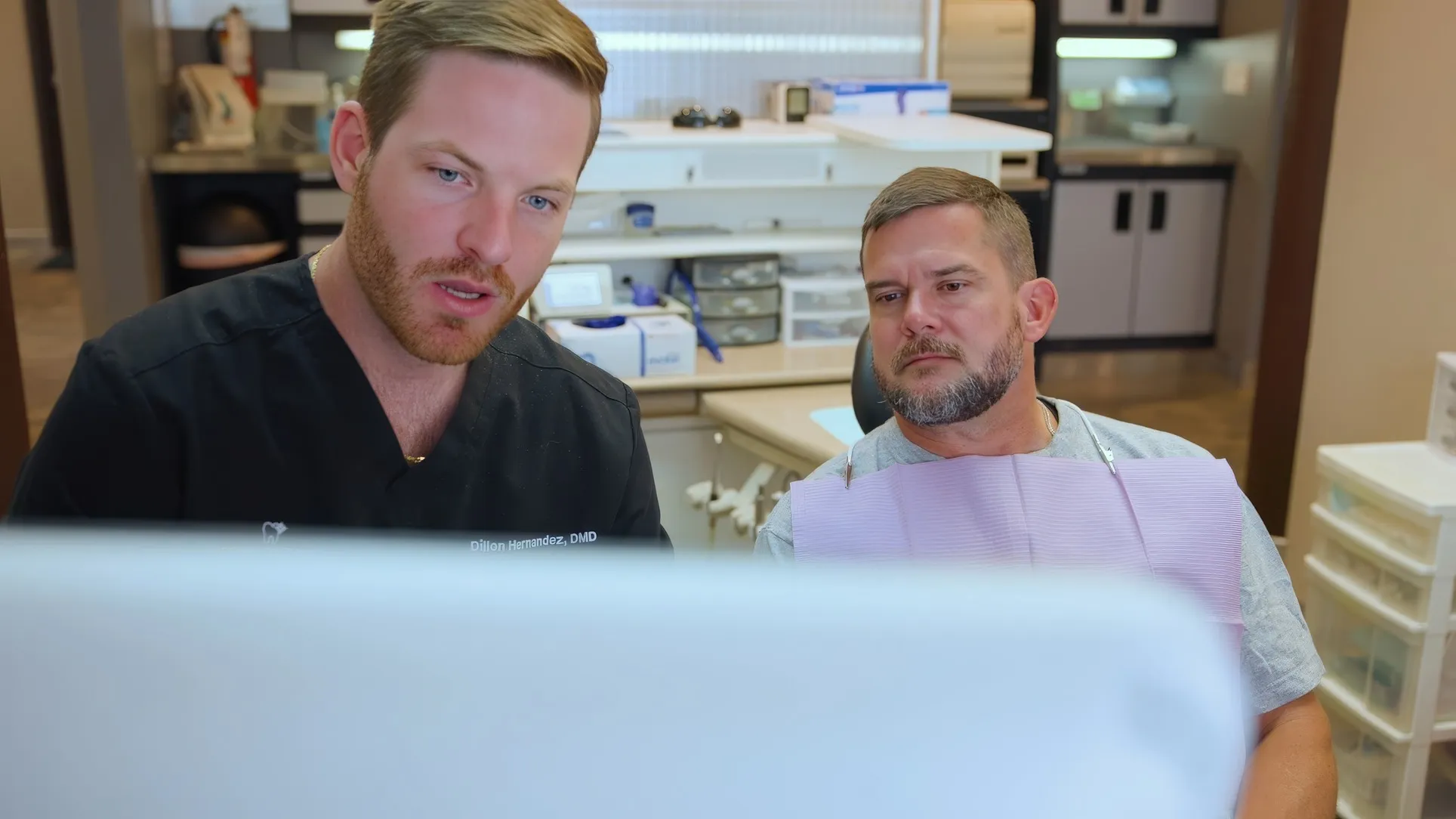 Dr. Dillon Hernandez and a patient reviewing exam images on a monitor at Cardinal Point Dental, at a Jacksonville, FL dental office offering restorative dentistry