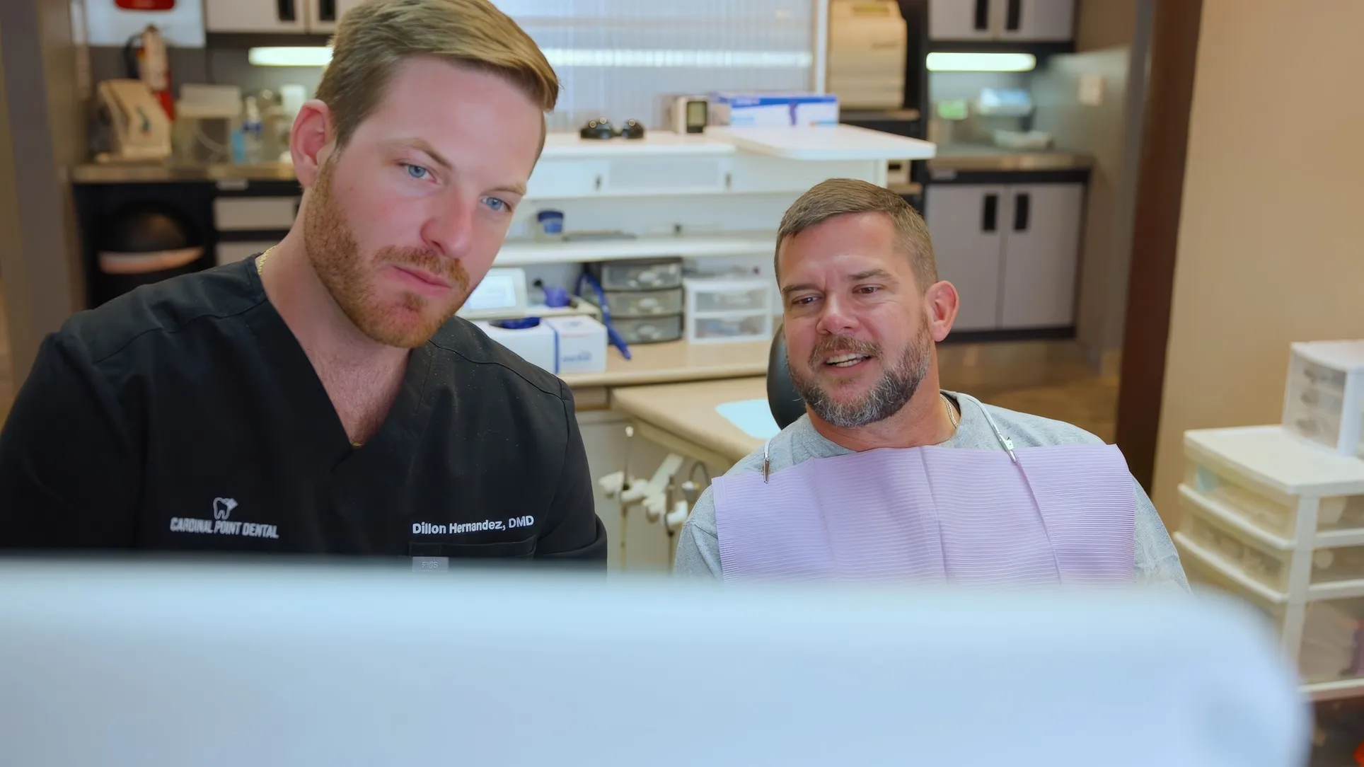 Dr. Dillon Hernandez and a patient looking at treatment images on a chairside monitor at Cardinal Point Dental — root canal treatment and exams in Jacksonville, FL