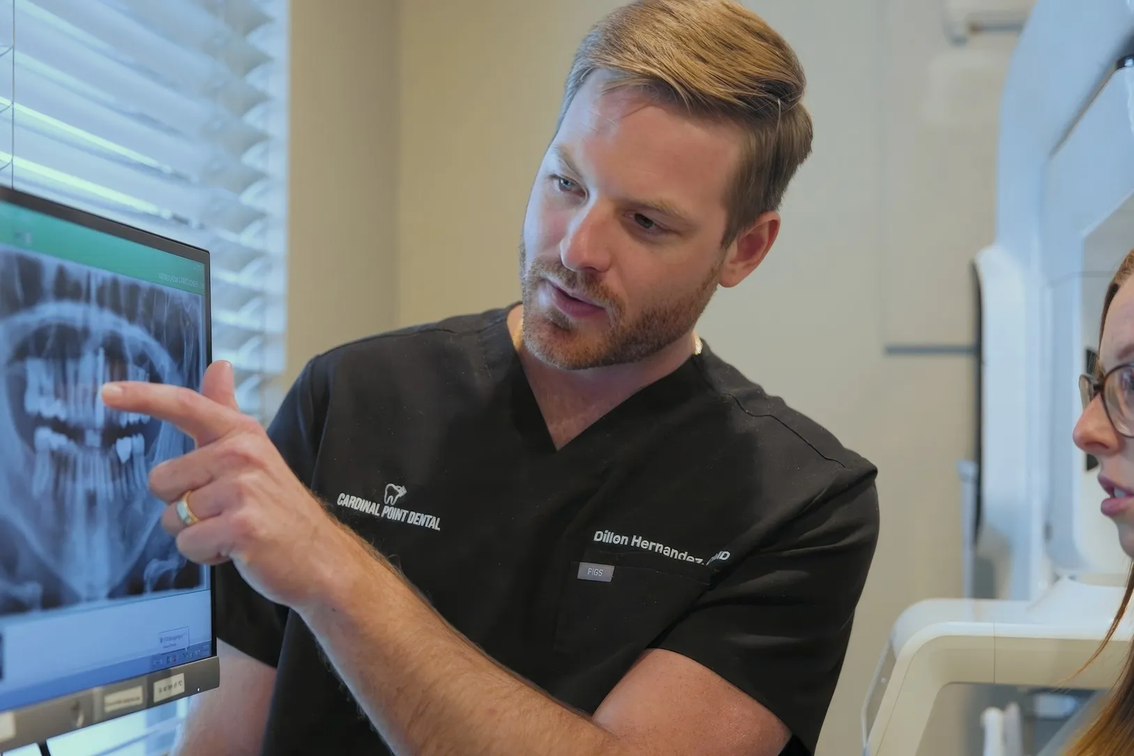 Dr. Dillon Hernandez reviewing a patient's panoramic X-ray on screen, the imaging used to plan dental implant treatment at Cardinal Point Dental in Jacksonville, FL