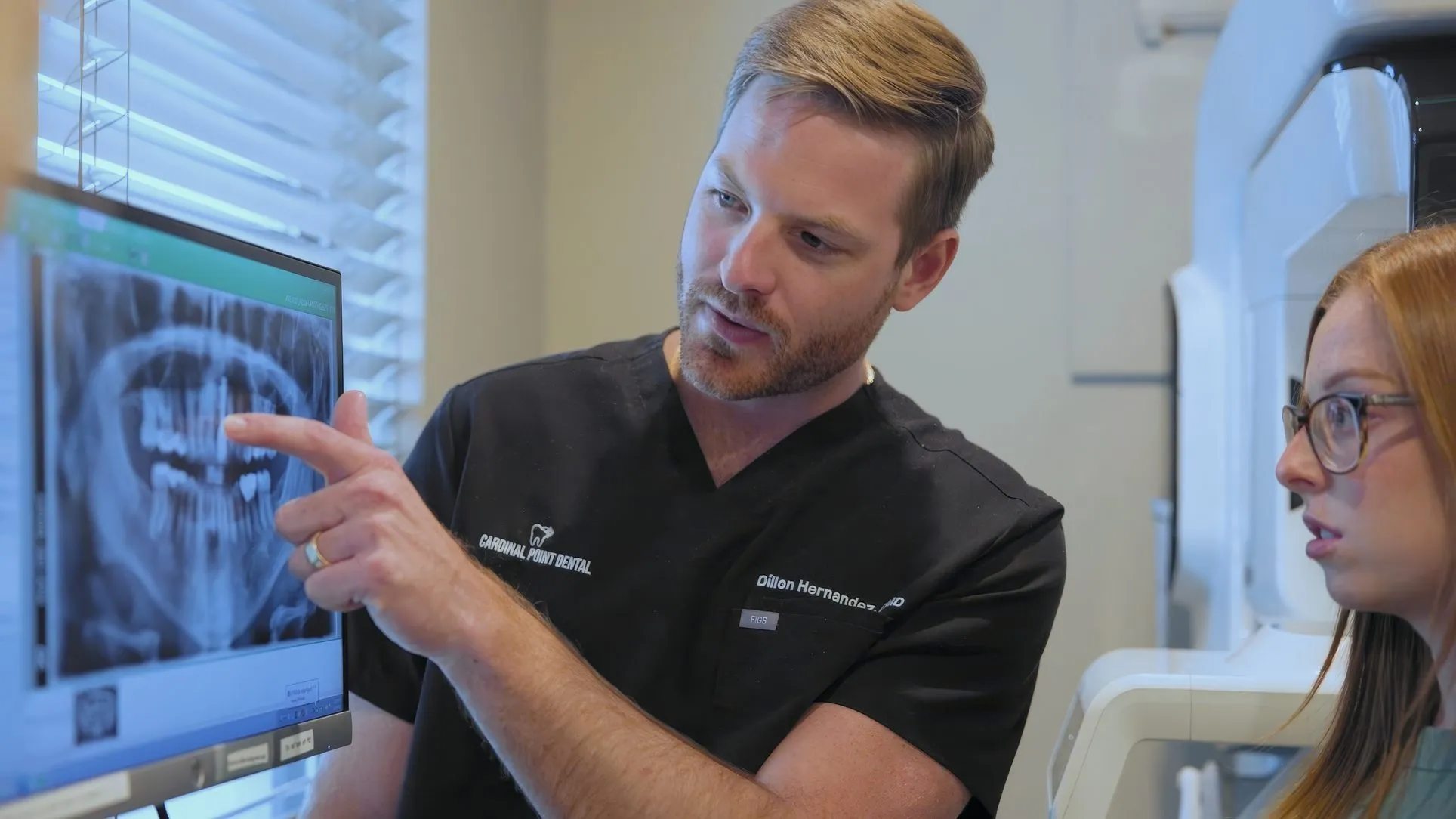 Dr. Dillon Hernandez pointing to a tooth on an X-ray with a team member at Cardinal Point Dental, Jacksonville, FL (smile makeovers)