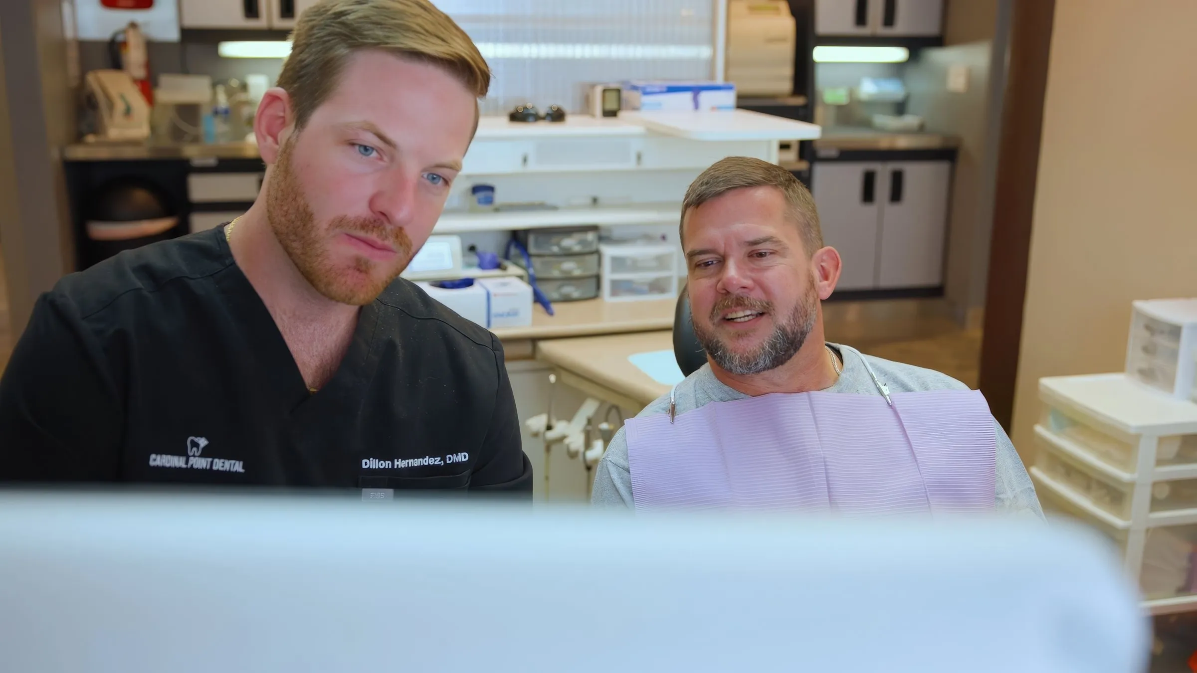 Dr. Dillon Hernandez and a patient looking at a screen together at Cardinal Point Dental, Jacksonville, FL (cavity reversal)