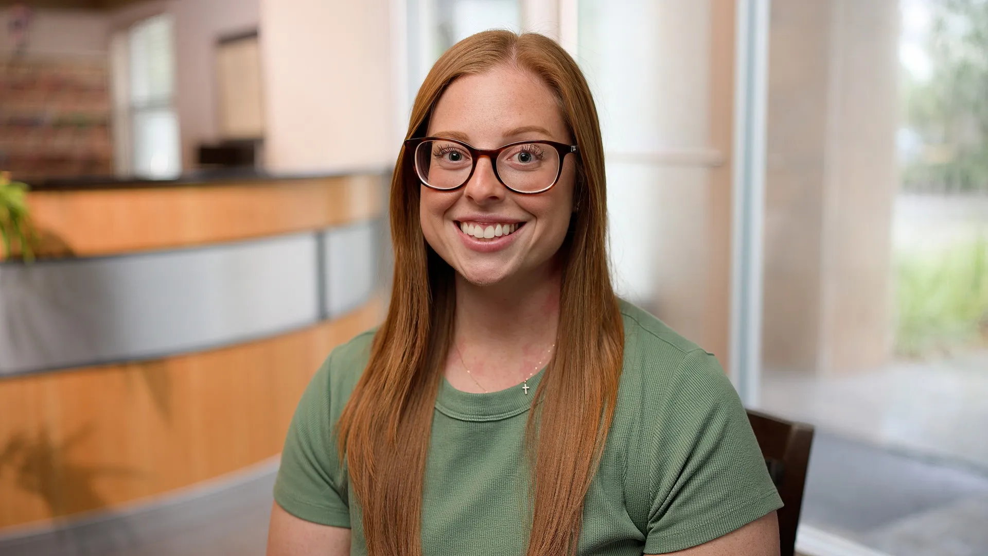 Lauren, a Cardinal Point Dental patient, smiling to camera in the office lobby — teeth cleanings and exams in Jacksonville, FL