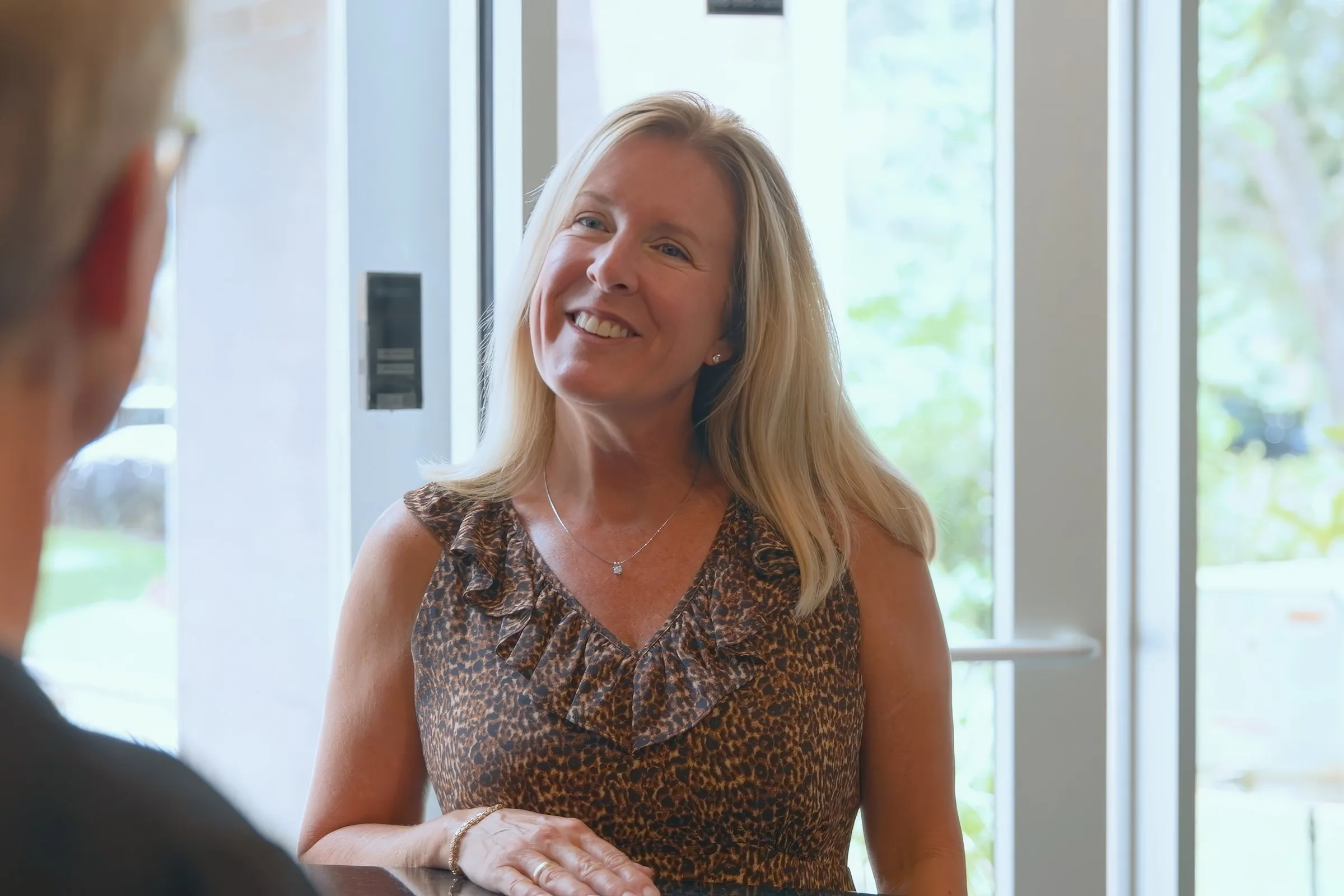 A smiling patient speaking with Cardinal Point Dental staff about dental implant treatment in Jacksonville, FL