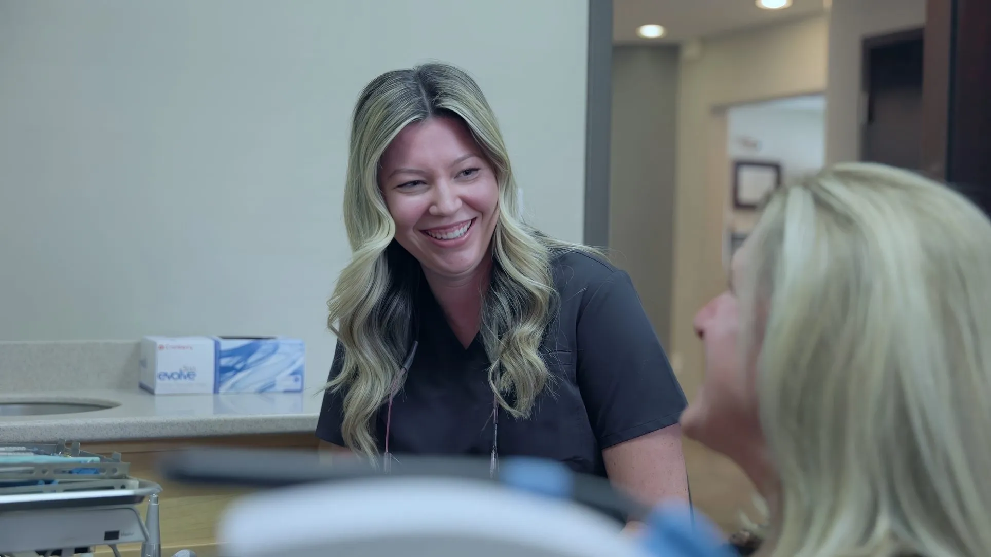 A smiling Cardinal Point Dental team member talking with a patient, at a Jacksonville, FL dental office offering veneers